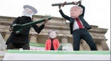 Atores vestidos como líderes religiosos Ali Chamenei, Angela Merkel e Donald Trump realizam uma ação de teatro de rua como parte de uma manifestação anti-guerra - Getty Images